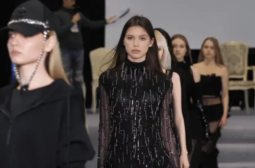 Model walking runway in sequined black dress at fashion show