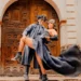 Steampunk couple embracing in front of a vintage door, showcasing dramatic fashion and accessories.
