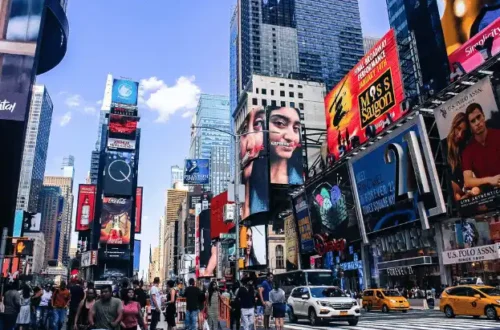 Bustling Times Square in New York with digital billboards and crowds.
