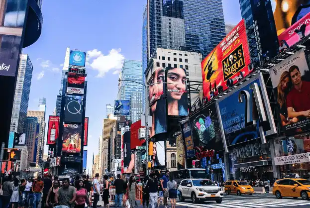 Bustling Times Square in New York with digital billboards and crowds.