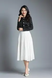Timeless elegance in a black top and white pleated skirt combination