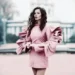 Woman in pink oversized blazer and matching dress posing on urban street