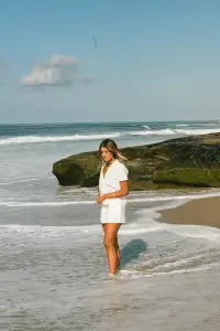 Retro aesthetic fashion captured with a model in a white outfit on the beach