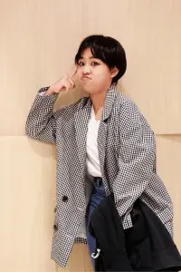 Tomboy style: woman in checkered coat with a confident, fun pose.