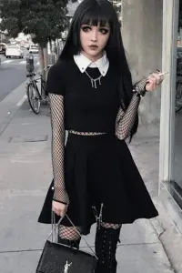 Alternative fashion look featuring black dress, fishnet accessories, gothic boots, and emo styling in urban setting

